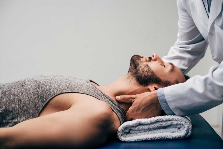 A health professional performing a gentle spinal adjustment on a patient lying on a therapy table.